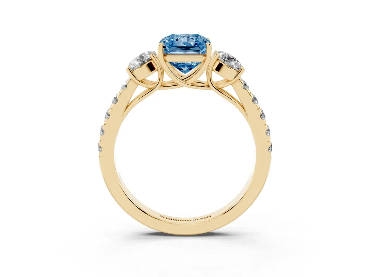 Fancy Blue Radiant Cut Cut Diamond Three-Stone Ring with Round Side Stones and Pavé Band Yellow gold