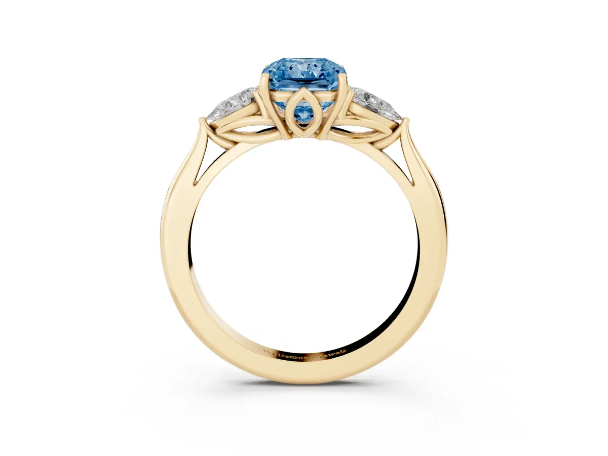 Fancy Blue Three-Stone Radiant Cut Diamond Ring with Pear Side Stones in Four-Prong Setting Yellow gold