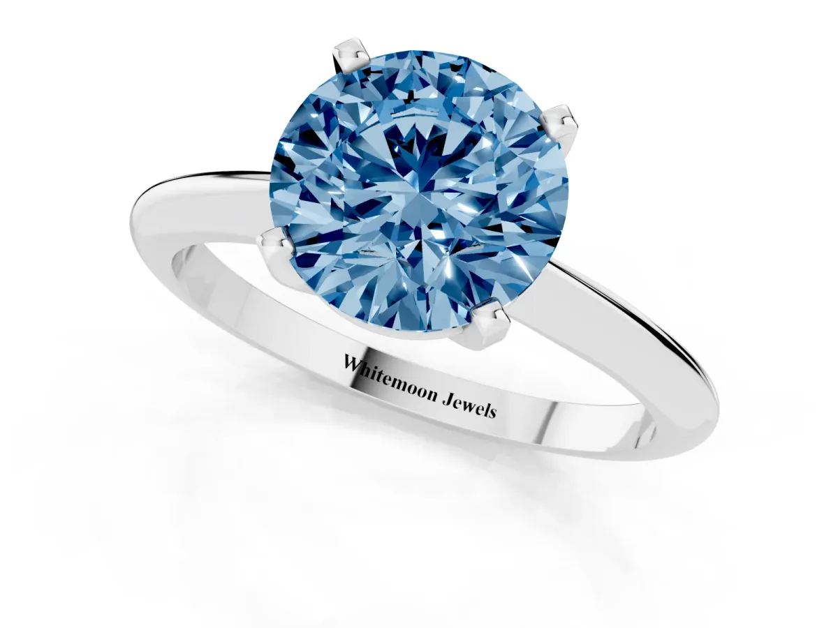 Fancy Blue Round Cut Cut Solitaire Ring with Four-Prong Setting on a Classic Band Silver