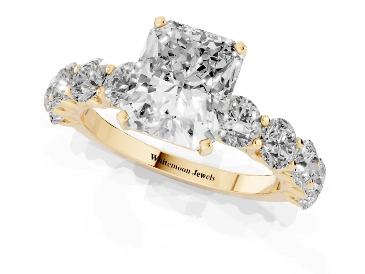 Radiant Cut Diamond Prong Setting with Side Stones on a Pave Band Yellow gold