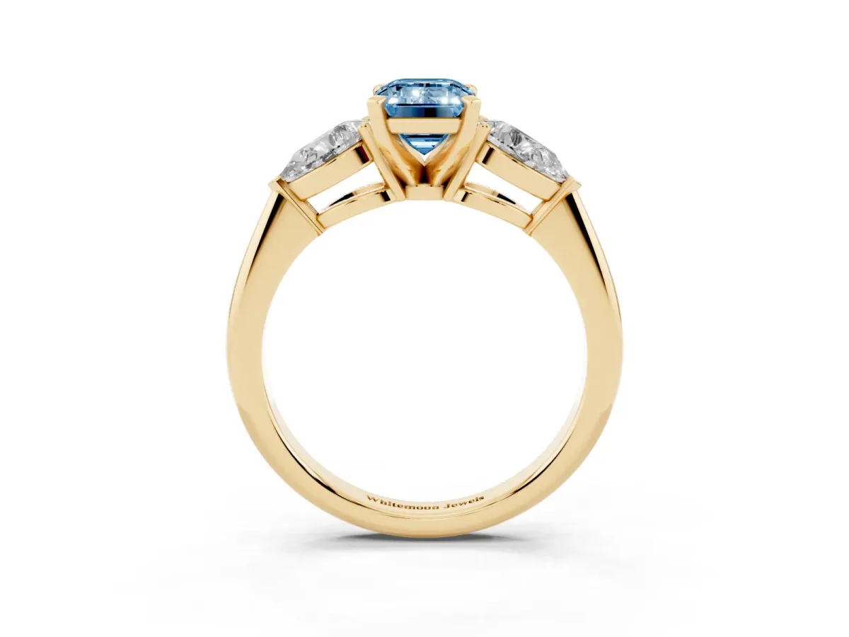 Fancy Blue Three-Stone Emerald Cut Diamond Ring with Pear Side Stones and Four-Prong Setting Yellow gold