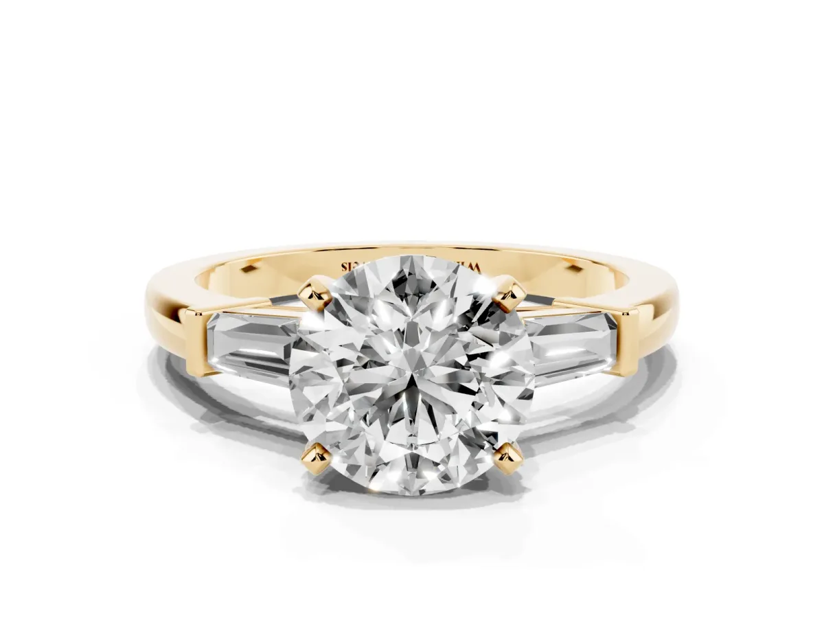 Round Cut Cut Diamond Solitaire Ring with Tapered Baguette Accents and Four-Prong Setting Yellow gold