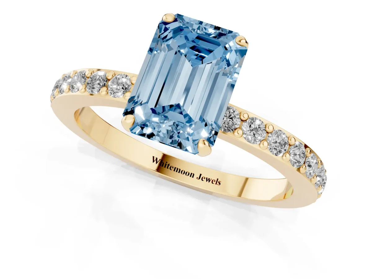 Fancy Blue Emerald Cut Diamond Pavé Engagement Ring with Round Accents and Prong Setting Yellow gold
