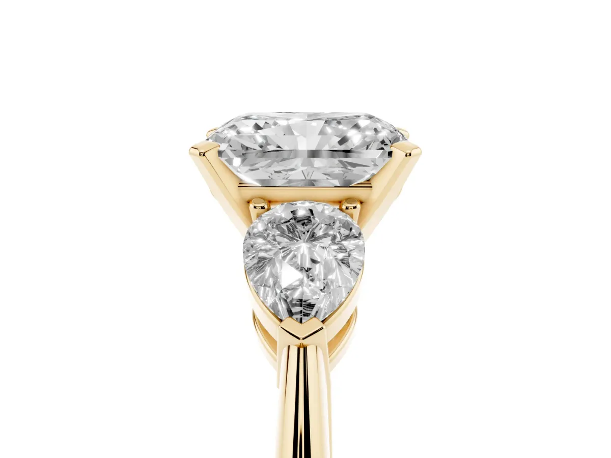 Three-Stone Radiant Cut Diamond Ring with Pear Side Stones and Four-Prong Setting Yellow gold