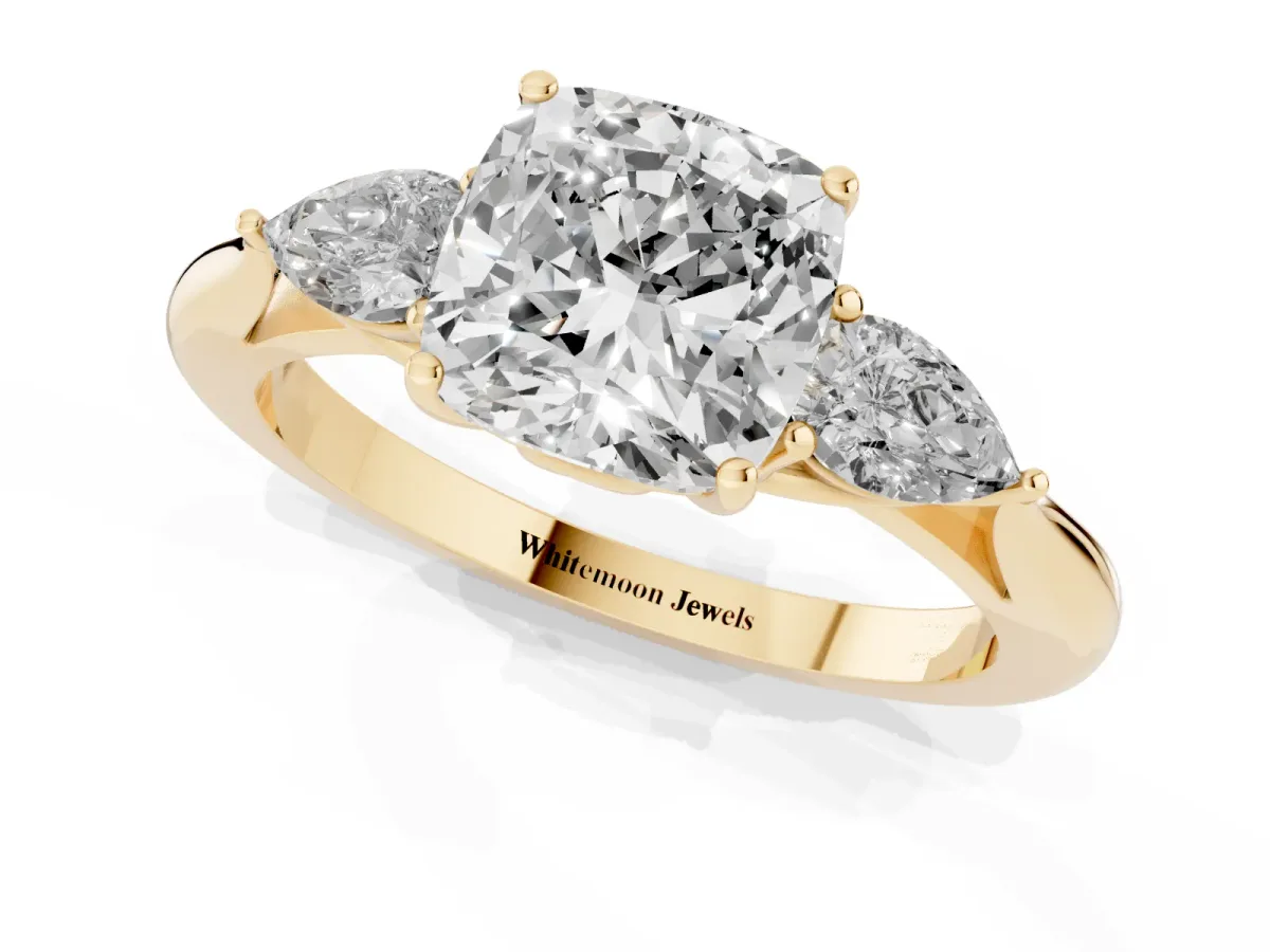 Three-Stone Cushion Cut Diamond Ring with Pear Side Stones in Four-Prong Setting Yellow gold