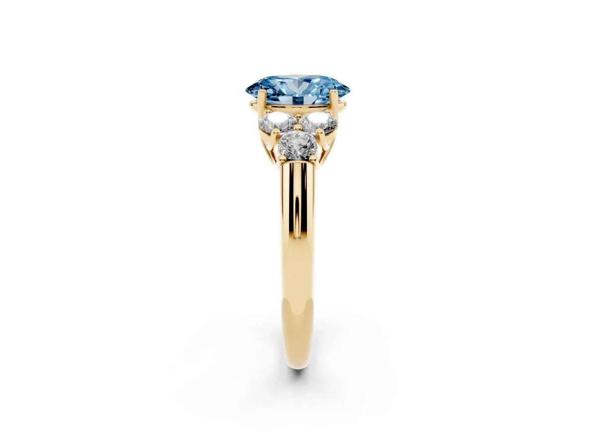 Fancy Blue Oval Cut Cut Diamond Cluster Ring with Round Accent Stones and Prong Setting on a Classic Band Yellow gold