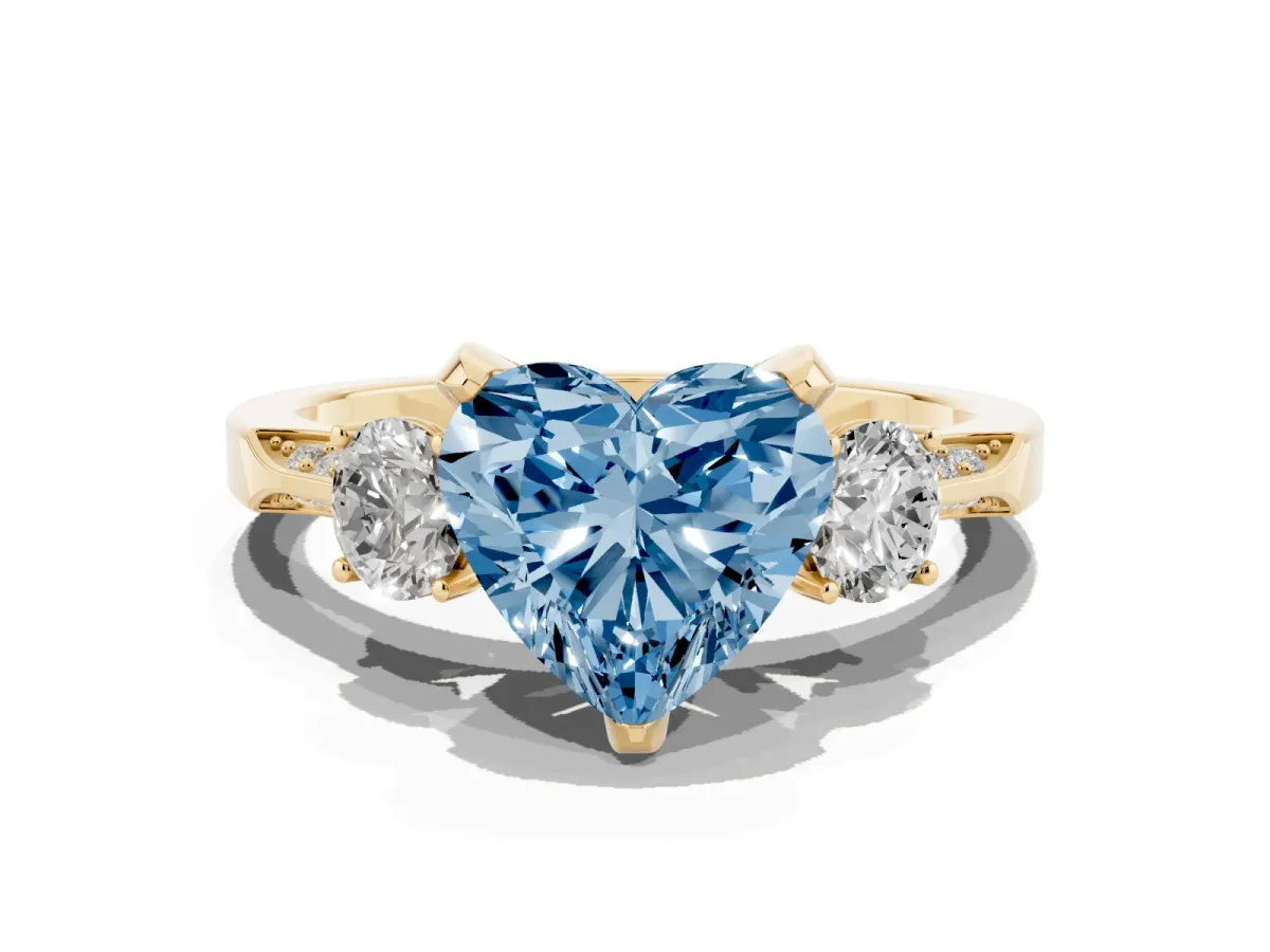 Fancy Blue Heart Cut Brilliant Three-Stone Diamond Ring with Pavé Band and Four-Prong Setting Yellow gold