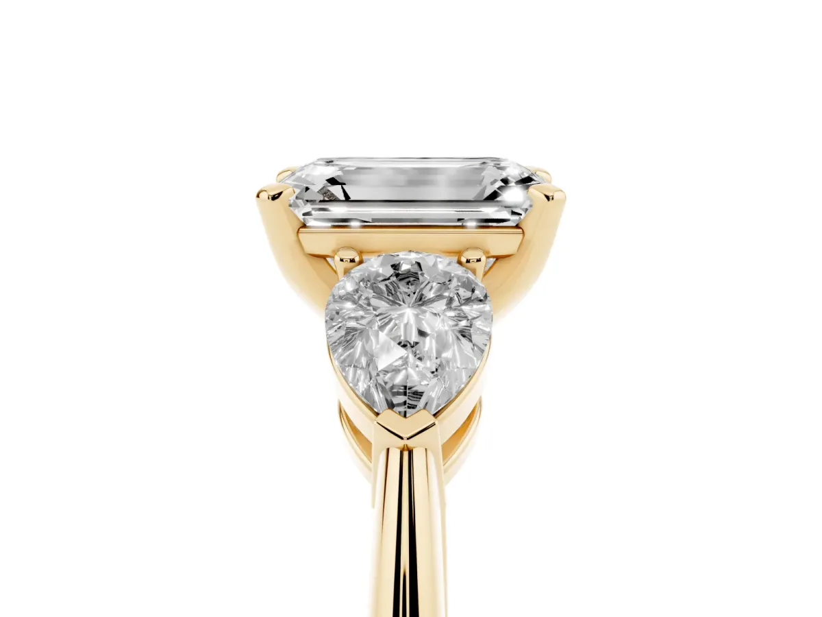 Three-Stone Emerald Cut Diamond Ring with Pear Side Stones and Four-Prong Setting Yellow gold