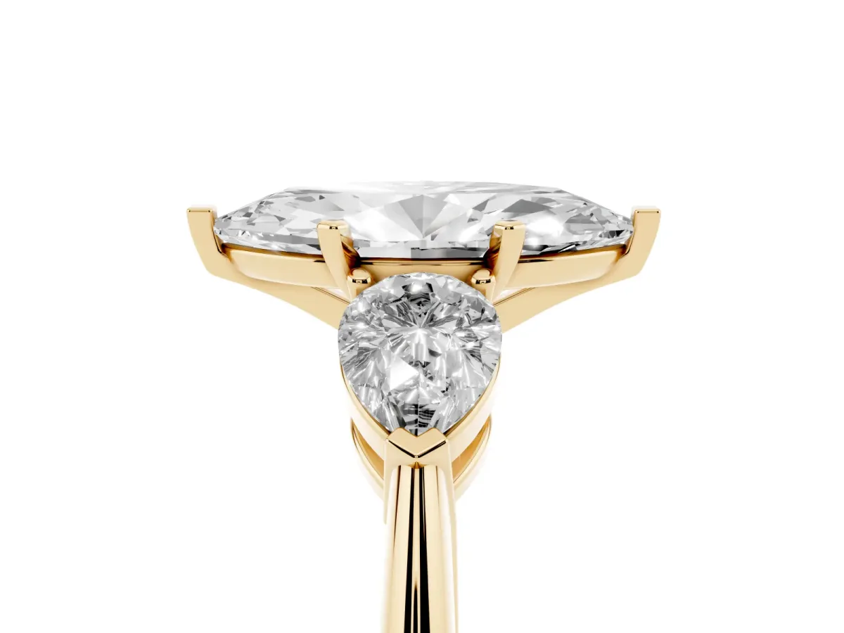 Three-Stone Marquise Cut Diamond Ring with Pear Side Stones and Four-Prong Setting Yellow gold