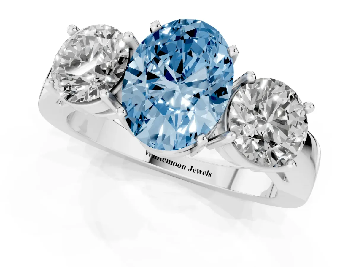 Fancy Blue Three-Stone Oval Cut Diamond Ring with Round Side Stones, Classic Band, and Four-Prong Setting White gold