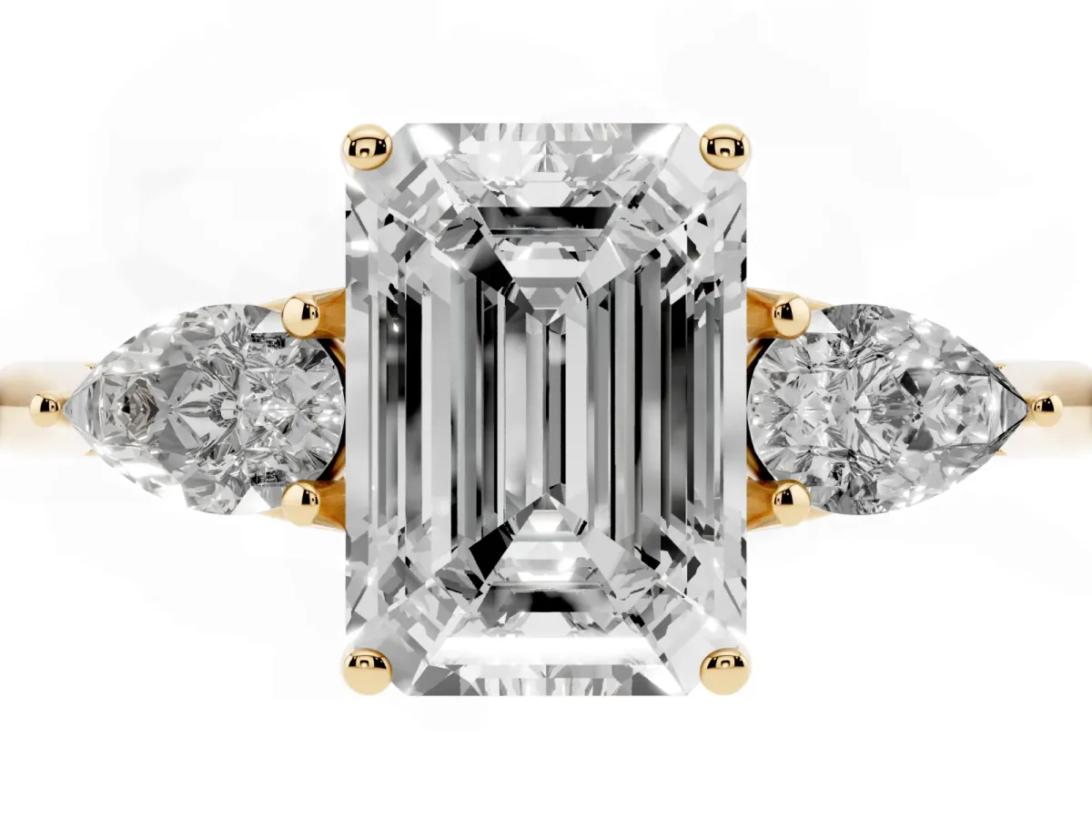 Three-Stone Emerald Cut Diamond Ring with Pear Side Stones in Four-Prong Setting Yellow gold
