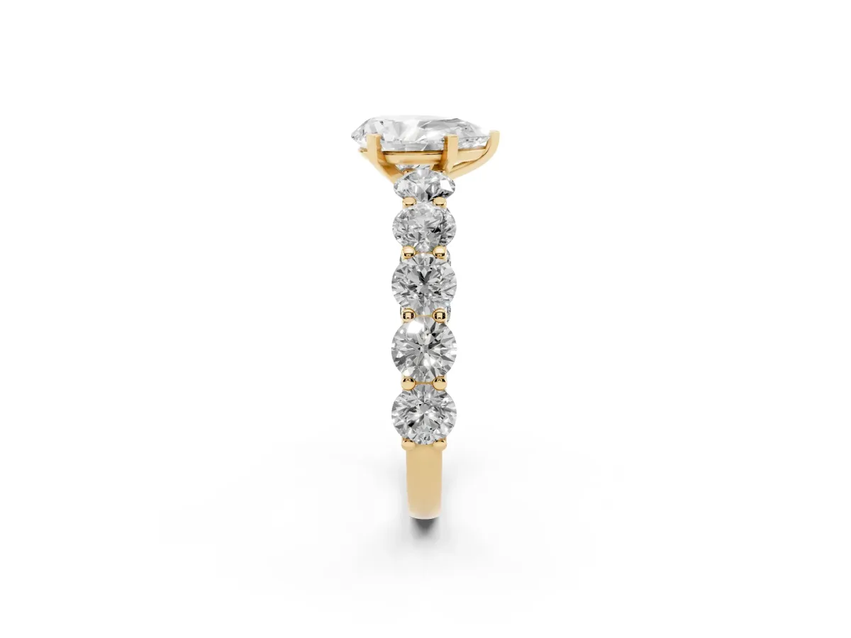 Pear Cut Diamond Prong Setting with Side Stones on a Pave Band Yellow gold