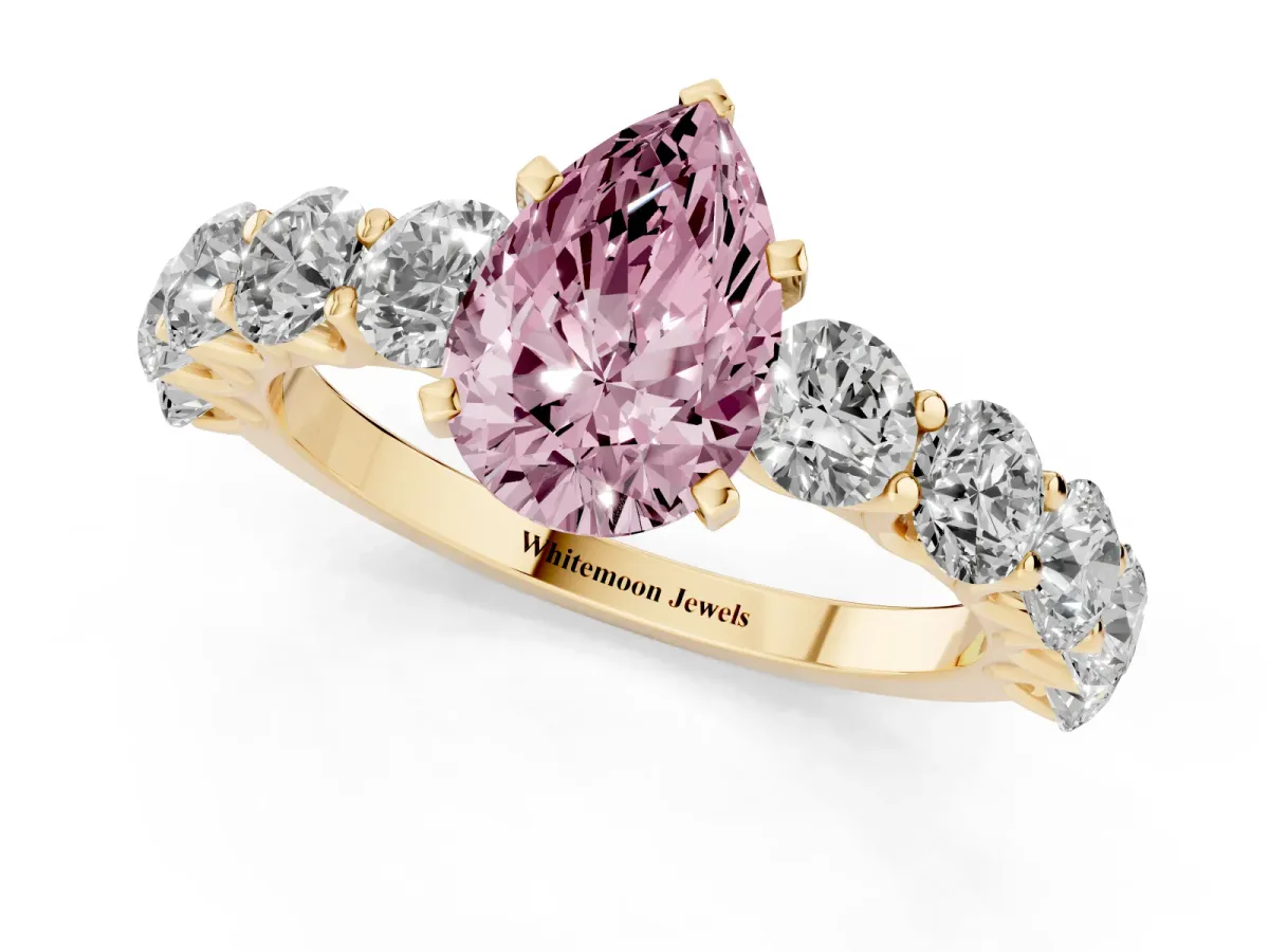 Fancy Pink Pear Cut Diamond Prong Setting with Side Stones on a Pave Band Yellow gold