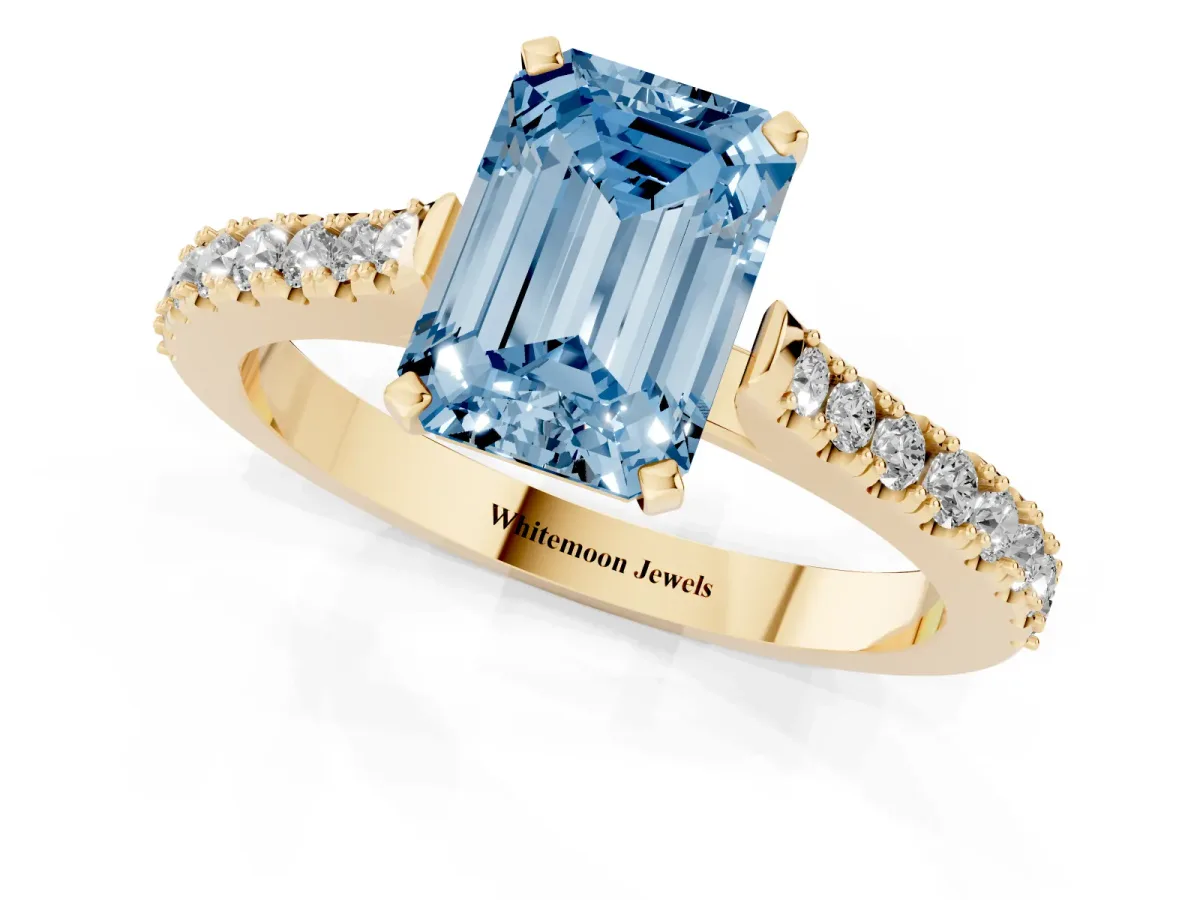 Fancy Blue Emerald Cut Cut Solitaire Diamond Engagement Ring with Pave Band and Four-Prong Setting Yellow gold