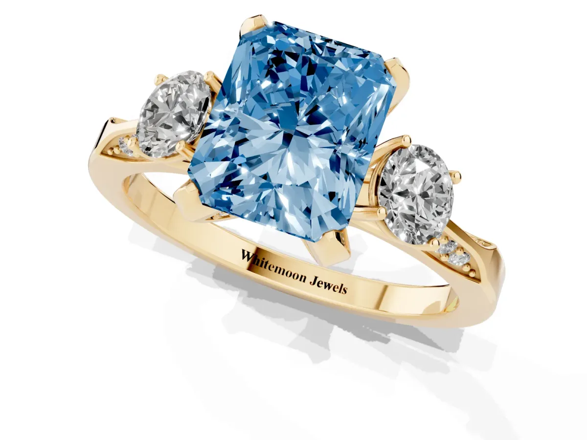 Fancy Blue Radiant Cut Brilliant Three-Stone Diamond Ring with Pavé Band and Four-Prong Setting Yellow gold