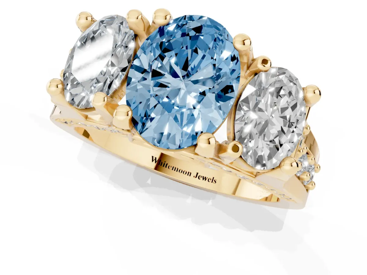 Fancy Blue Oval Cut Diamond Three-Stone Ring with Channel Set Band and Four-Prong Setting Yellow gold