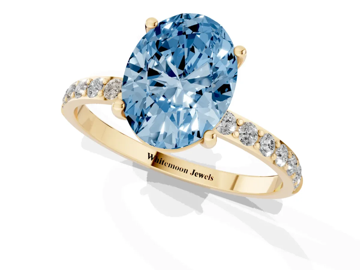 Fancy Blue Oval Cut Diamond Solitaire Ring with Round Pavé Shoulders and Prong Setting Yellow gold