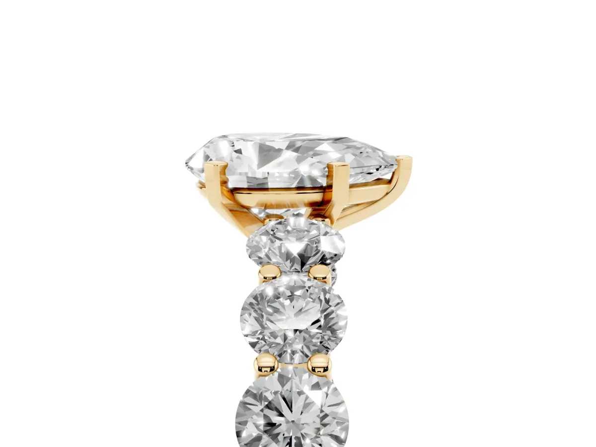 Pear Cut Diamond Prong Setting with Side Stones on a Pave Band Yellow gold