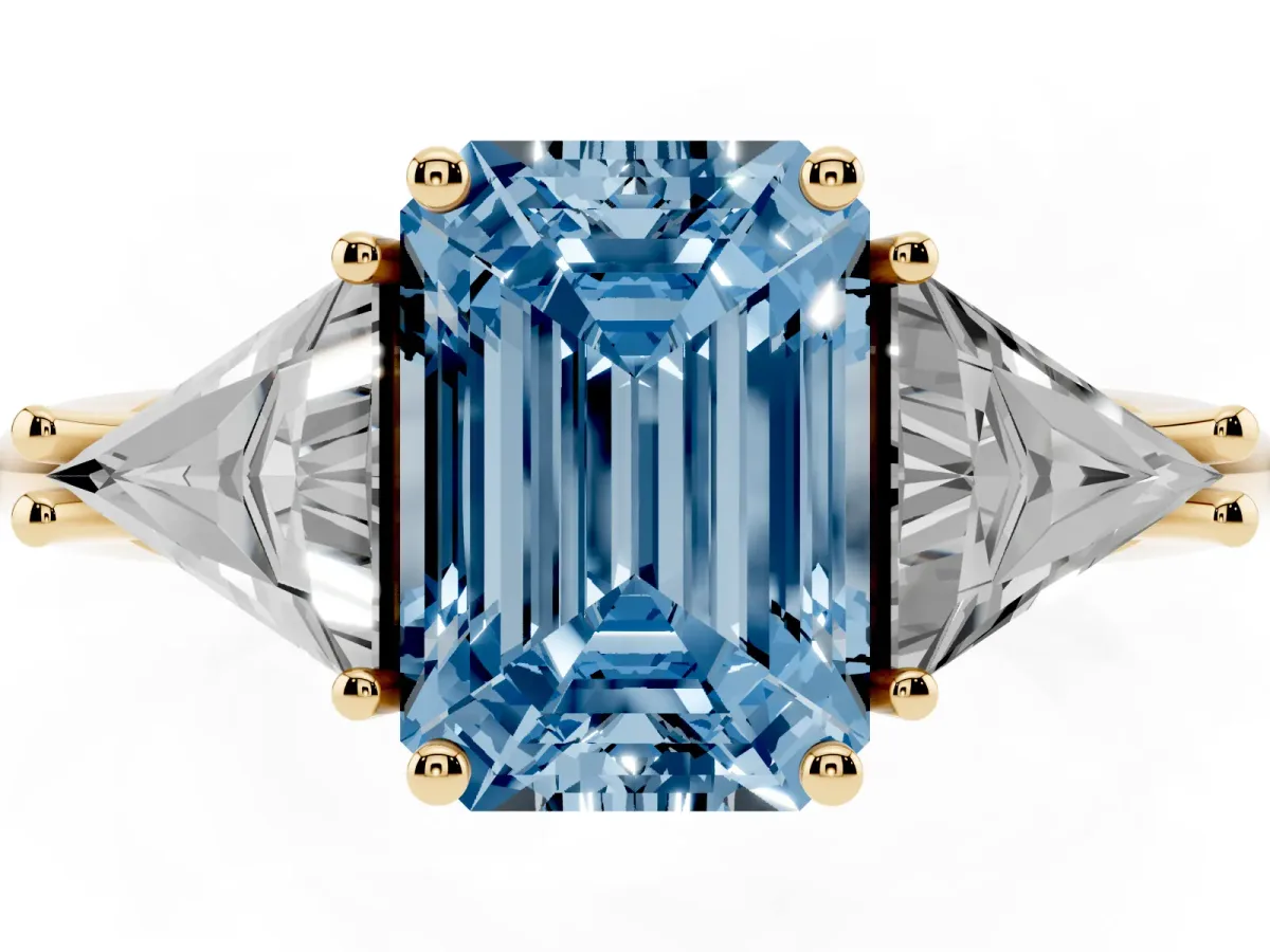 Fancy Blue Three-Stone Emerald Cut Diamond Engagement Ring with Trillion Side Stones and Prong Setting Yellow gold
