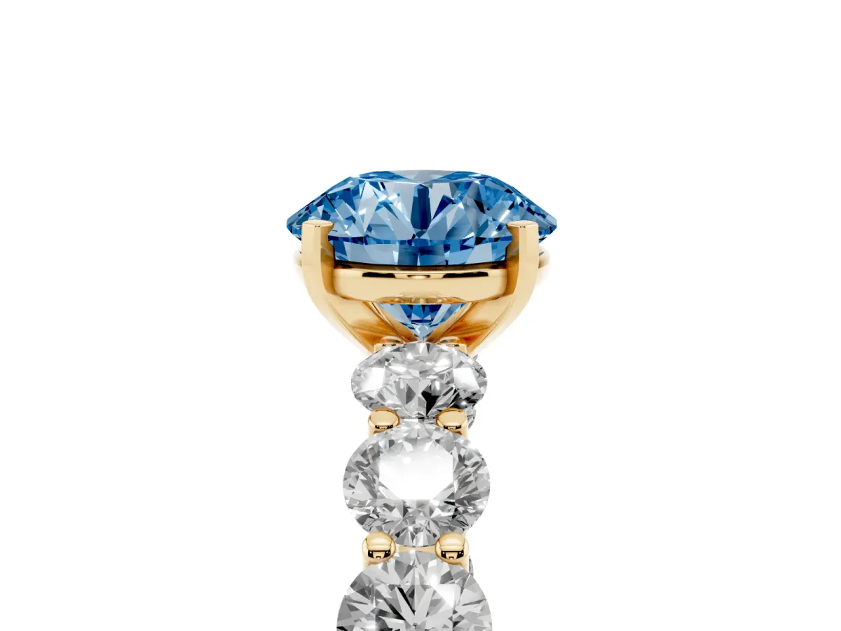Fancy Blue Round Cut Diamond Prong Setting with Side Stones on a Pave Band Yellow gold