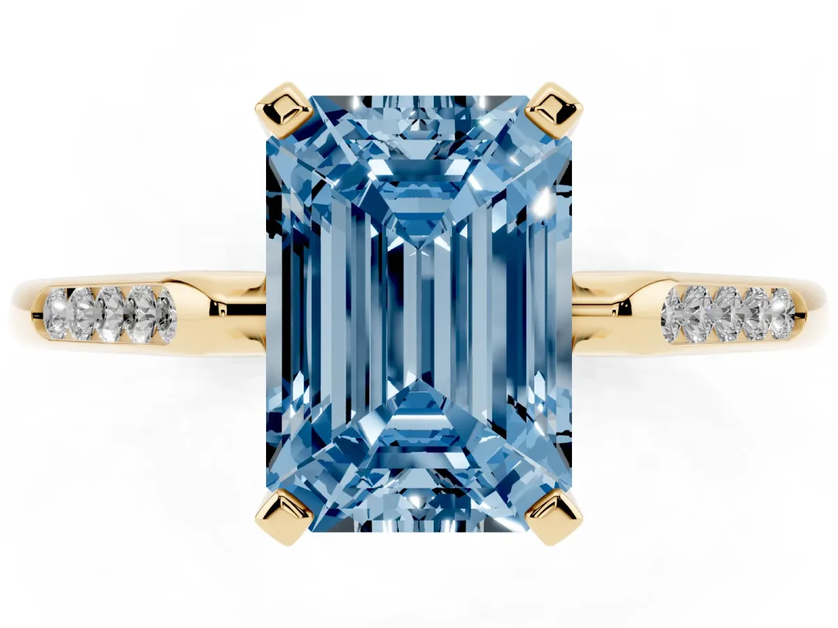 Fancy Blue Emerald Cut Diamond Solitaire Ring with Channel Set Round Band and Prong Setting Yellow gold