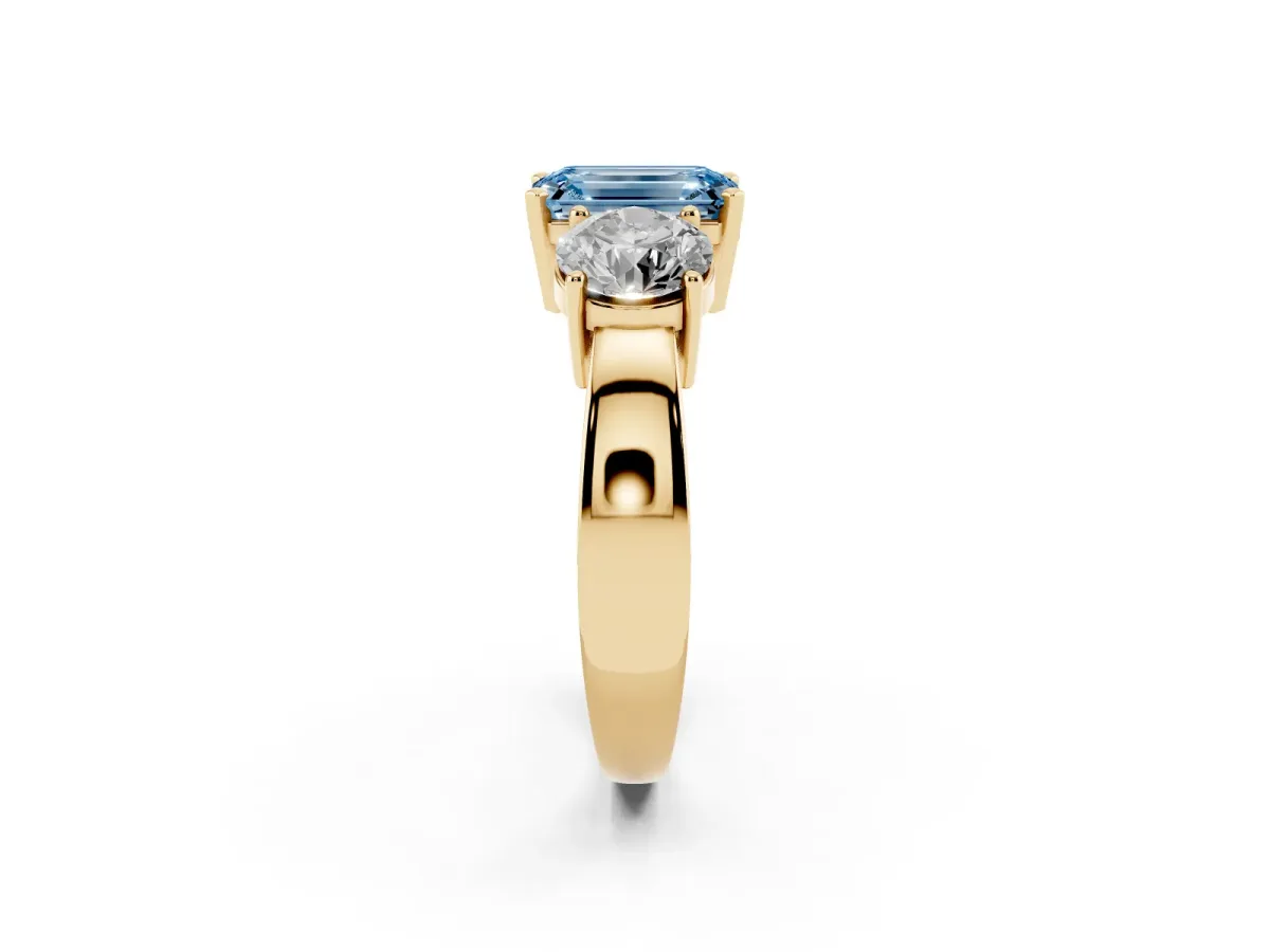 Fancy Blue Three-Stone Emerald Cut Diamond Ring with Round Side Stones, Classic Band, and Four-Prong Setting Yellow gold