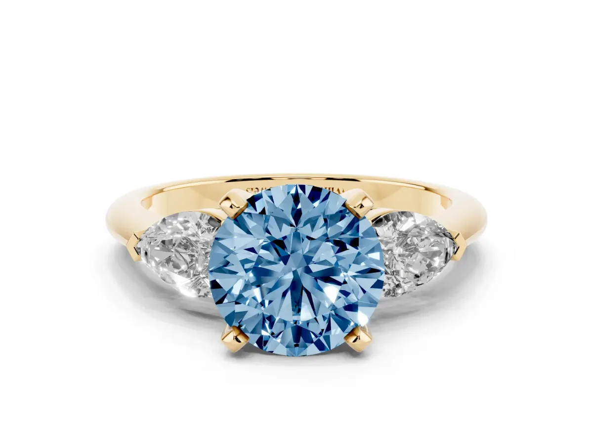 Fancy Blue Three-Stone Round Cut Diamond Ring with Pear Side Stones and Four-Prong Setting Yellow gold