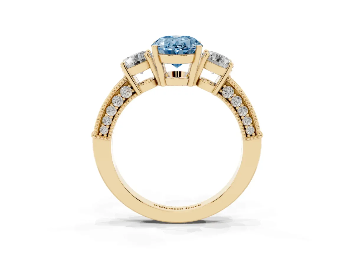 Fancy Blue Oval Cut Three-Stone Diamond Ring with Pavé Band and Four-Prong Setting Yellow gold