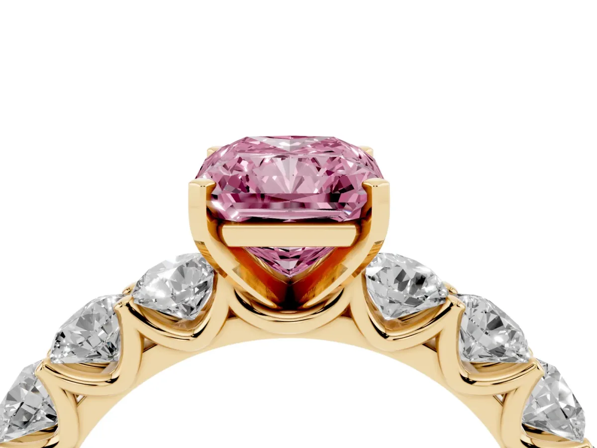 Fancy Pink Radiant Cut Diamond Prong Setting with Side Stones on a Pave Band Yellow gold