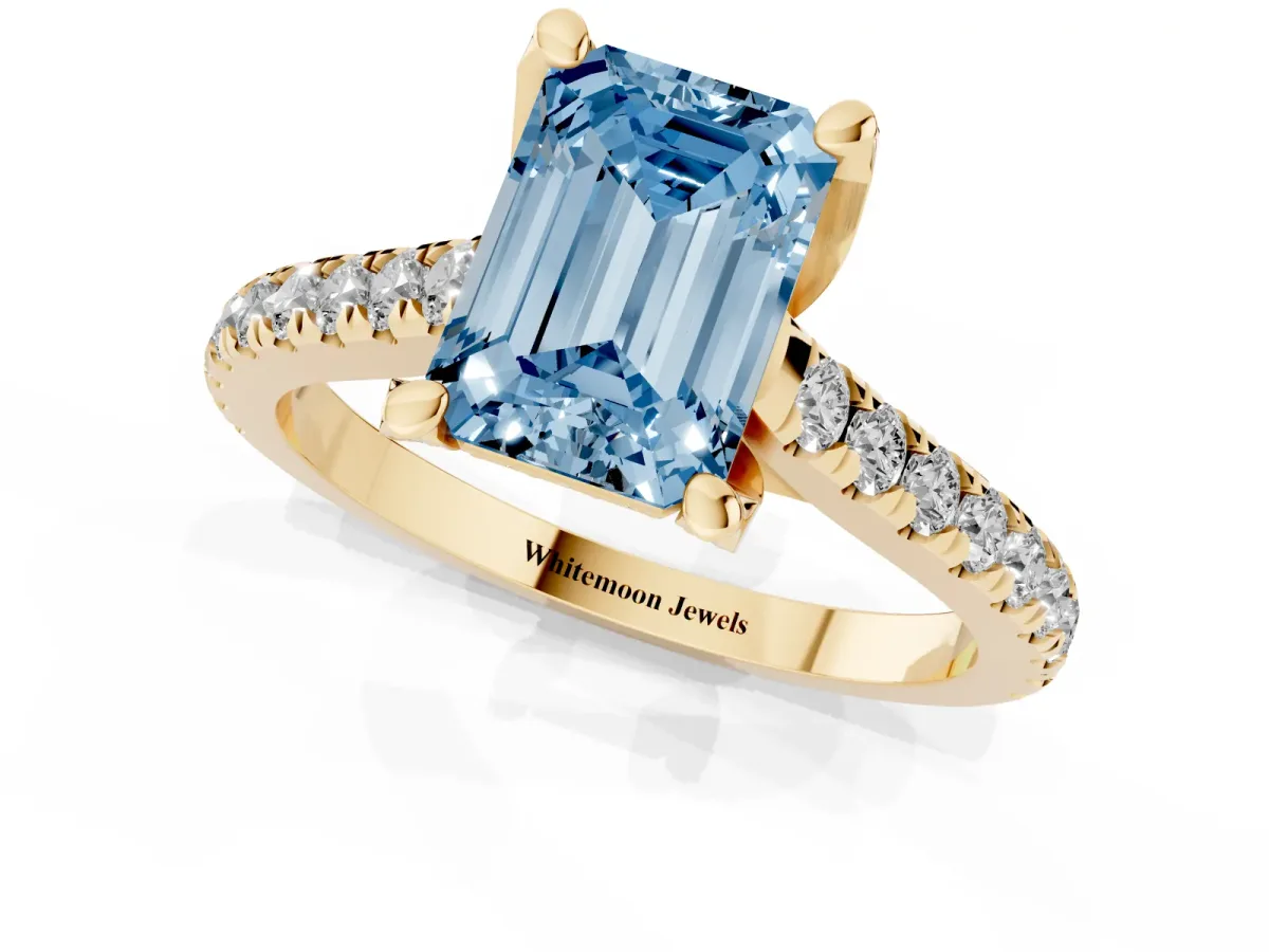 Fancy Blue Emerald Cut Brilliant Diamond Solitaire with Pavé Band and Four-Prong Setting Yellow gold