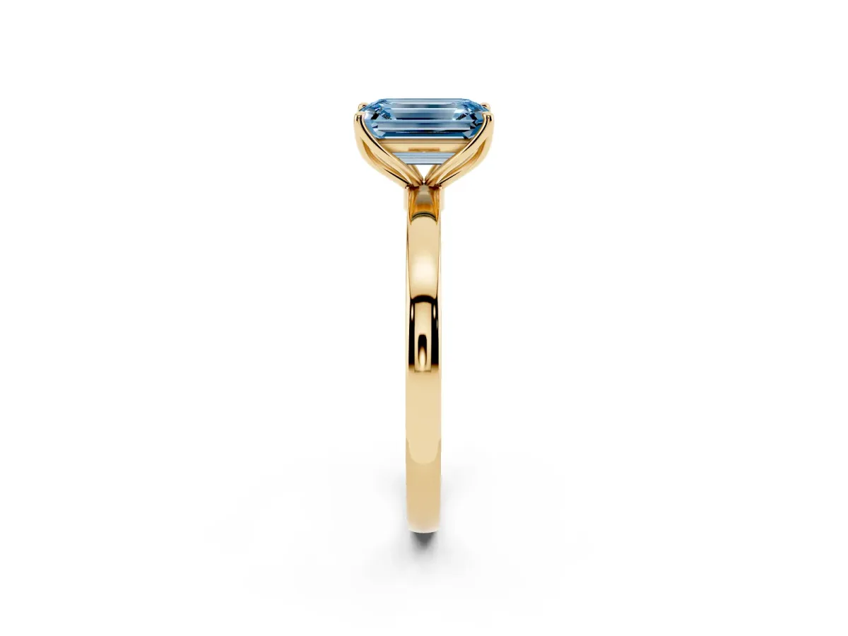 Fancy Blue Emerald Cut Diamond Solitaire Ring with Thin Band and Prong Setting Yellow gold