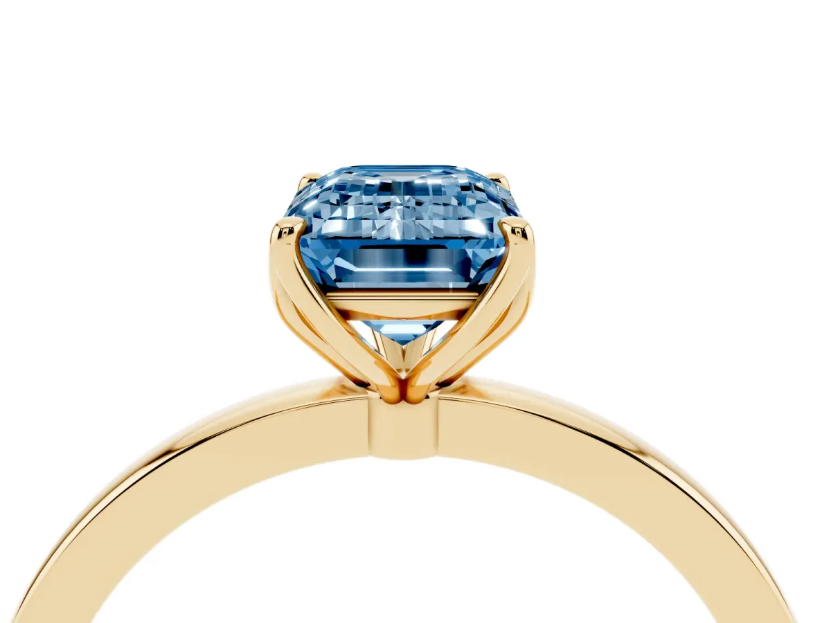 Fancy Blue Emerald Cut Diamond Solitaire Ring with Thin Band and Prong Setting Yellow gold