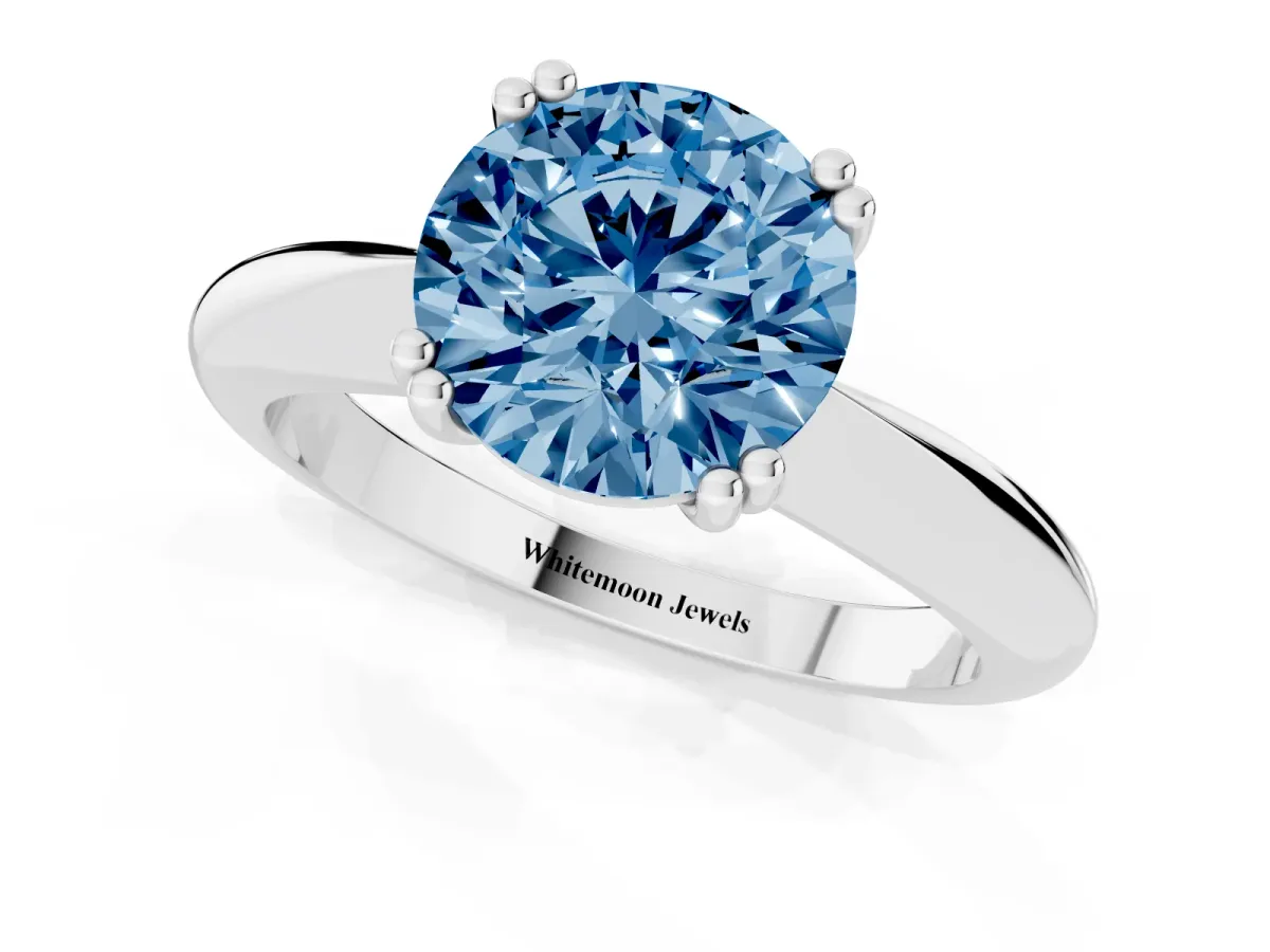 Fancy Blue Round Cut Cut Solitaire Engagement Ring with Tapered Band and Four-Prong Setting Silver