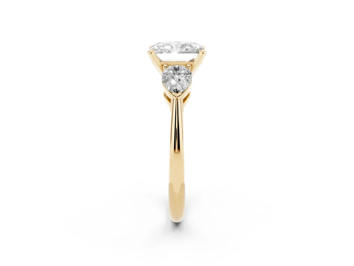 Three-Stone Radiant Cut Diamond Ring with Pear Side Stones and Four-Prong Setting Yellow gold