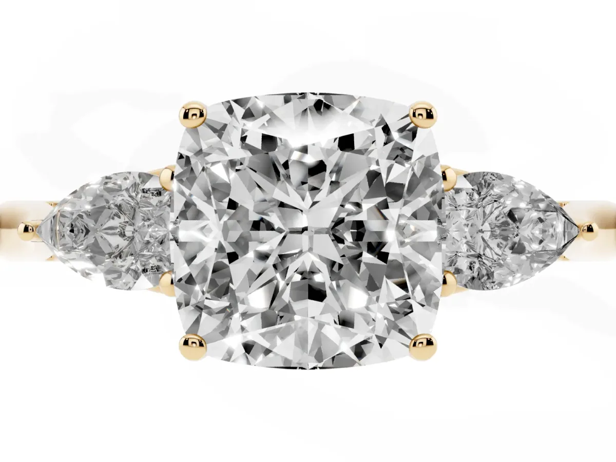 Three-Stone Cushion Cut Diamond Ring with Pear Side Stones in Four-Prong Setting Yellow gold