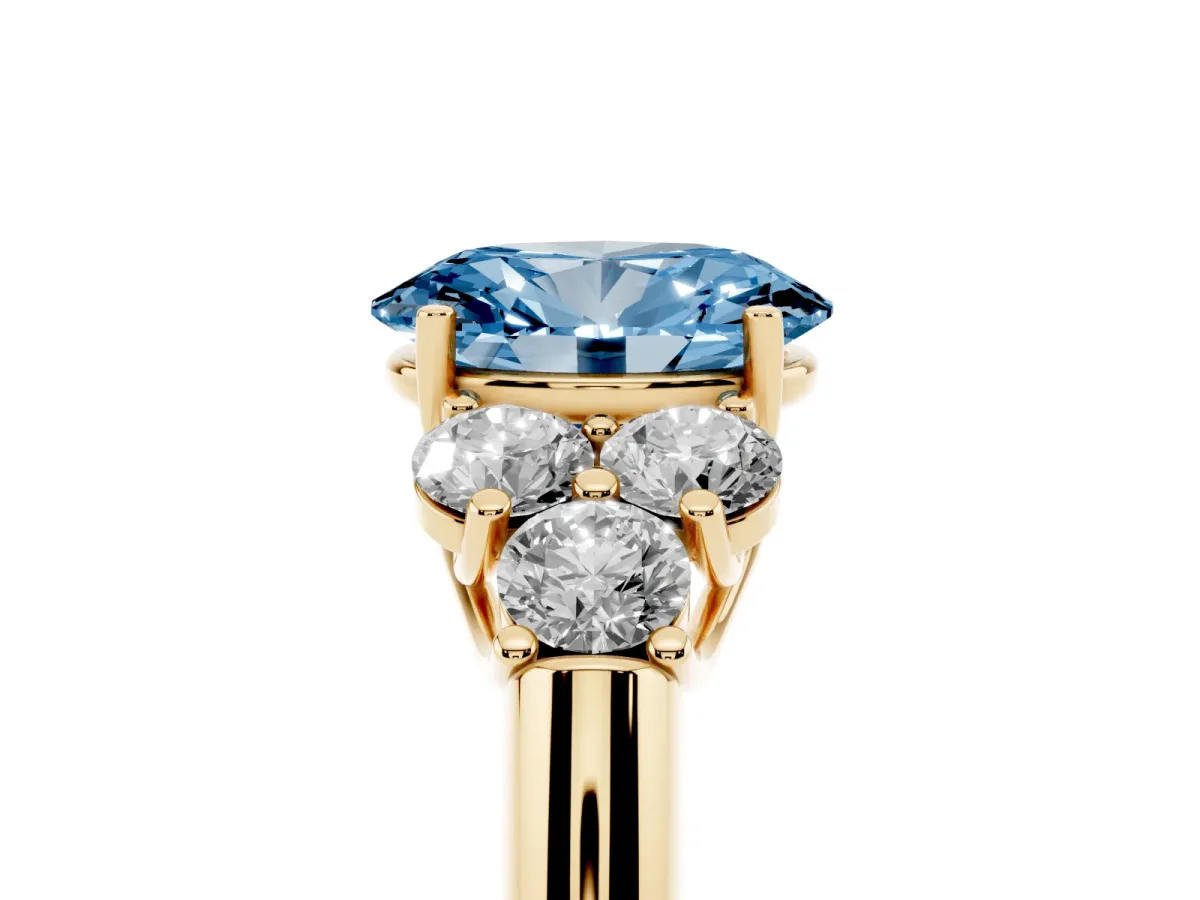 Fancy Blue Oval Cut Cut Diamond Cluster Ring with Round Accent Stones and Prong Setting on a Classic Band Yellow gold