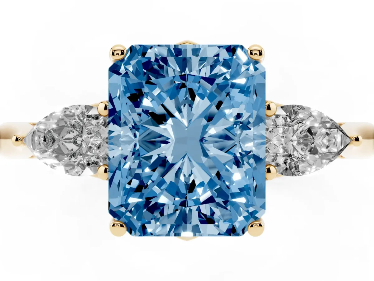 Fancy Blue Three-Stone Radiant Cut Diamond Ring with Pear Side Stones in Four-Prong Setting Yellow gold