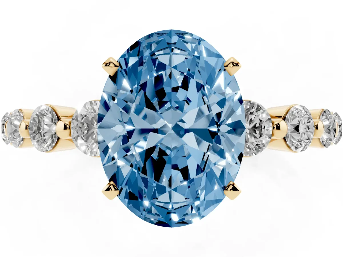 Fancy Blue Oval Cut Solitaire Diamond Ring with Pave Band and Four-Prong Setting Yellow gold