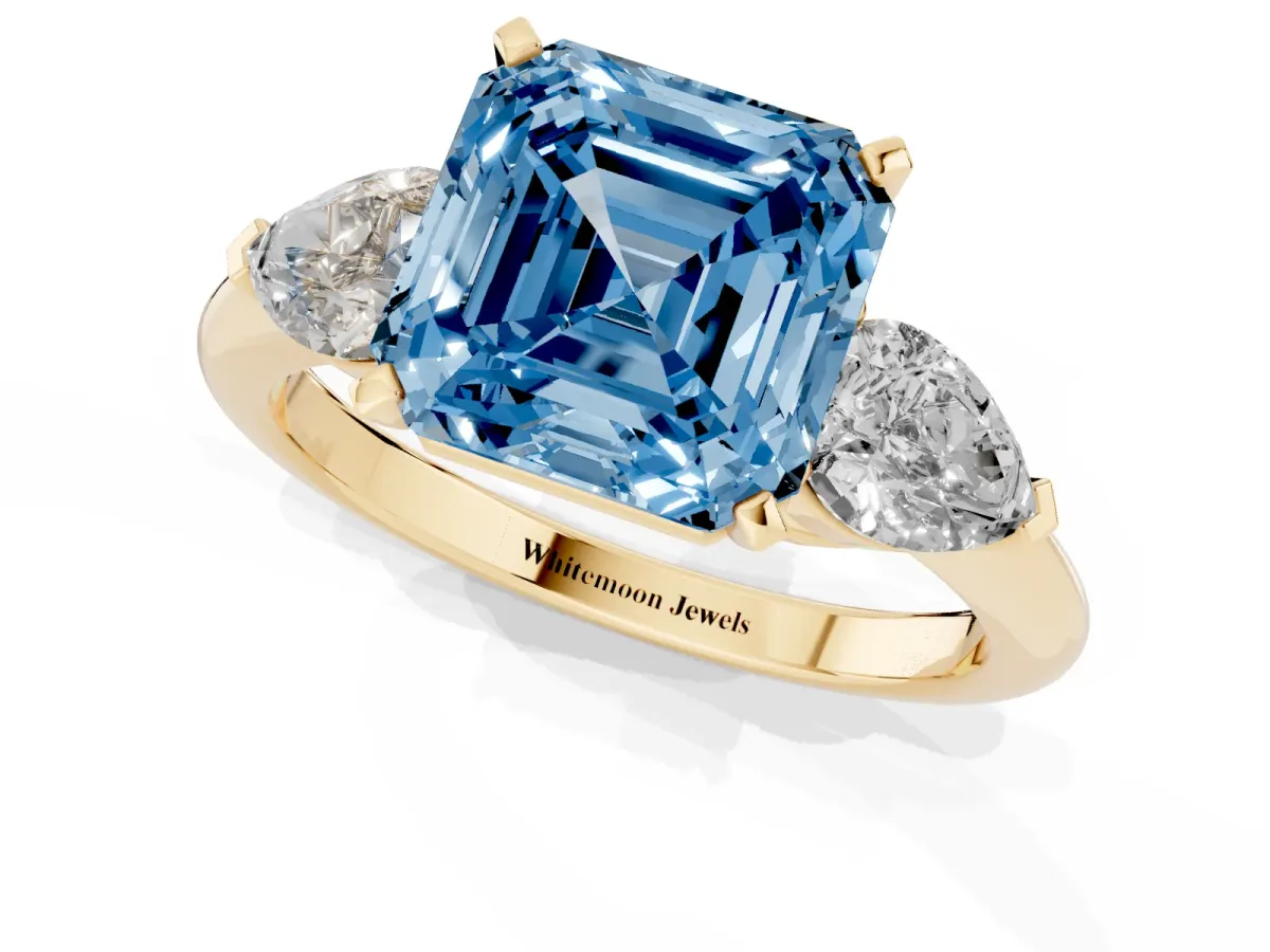 Fancy Blue Three-Stone Asscher Cut Diamond Ring with Pear Side Stones and Four-Prong Setting Yellow gold
