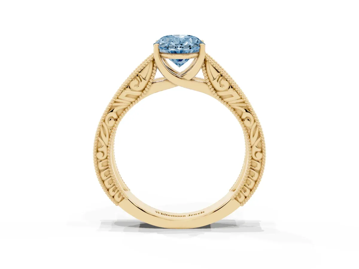 Fancy Blue Oval Cut Diamond Solitaire Ring with Engraved Band and Four-Prong Setting Yellow gold