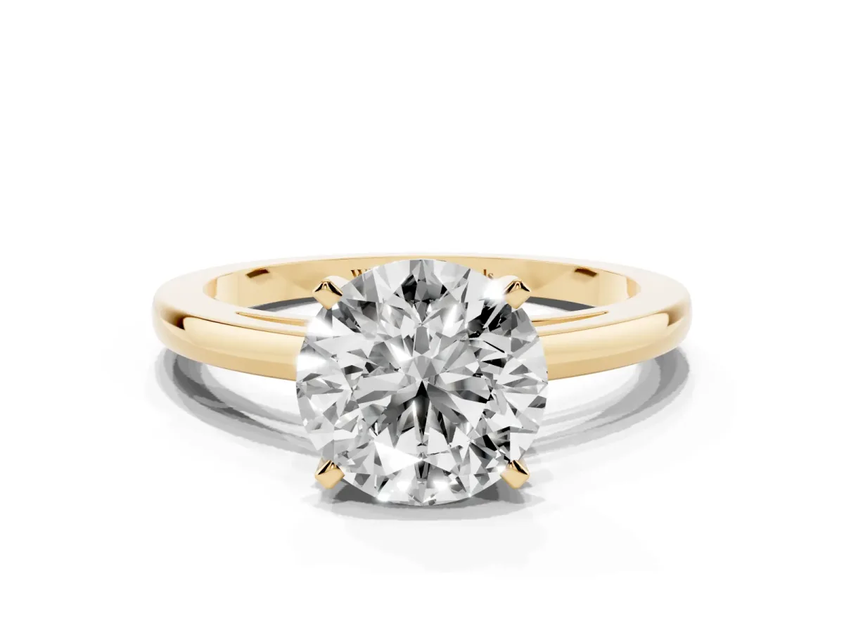 Round Cut Solitaire Diamond Engagement Ring with Four-Prong Setting on a Classic Band Yellow gold