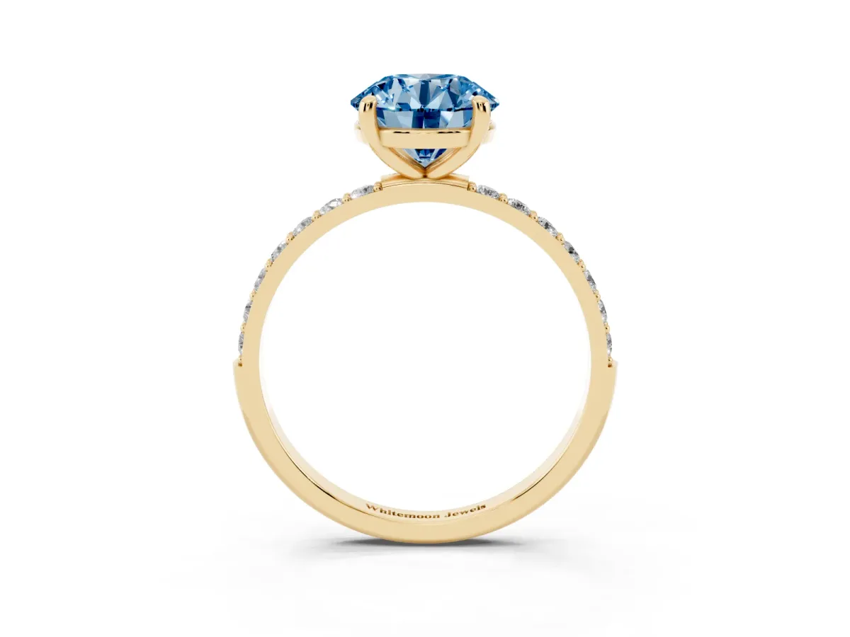 Fancy Blue Round Cut Diamond Solitaire Ring with Round Pavé Band and Prong Setting Yellow gold