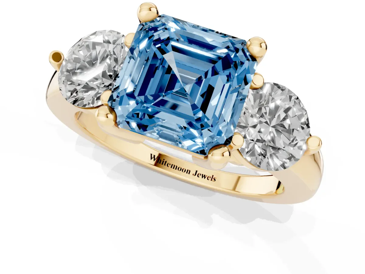 Fancy Blue Three-Stone Asscher Cut Brilliant Cut Solitaire Ring with Prong Setting on a Classic Band Yellow gold
