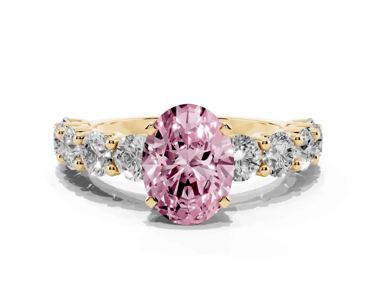 Fancy Pink Oval Cut Diamond Prong Setting with Side Stones on a Pave Band Yellow gold