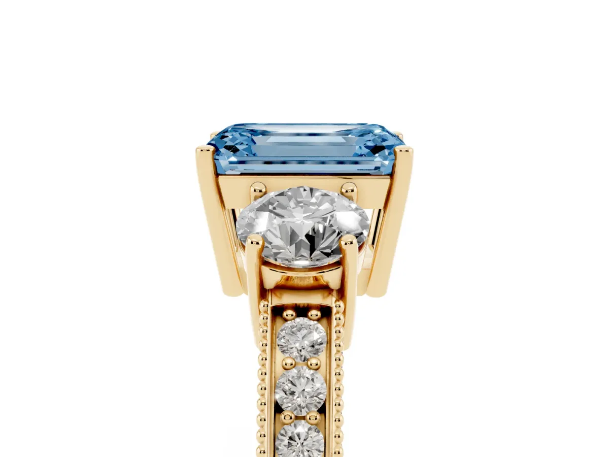 Fancy Blue Emerald Cut Three-Stone Diamond Ring with Pavé Band and Four-Prong Setting Yellow gold