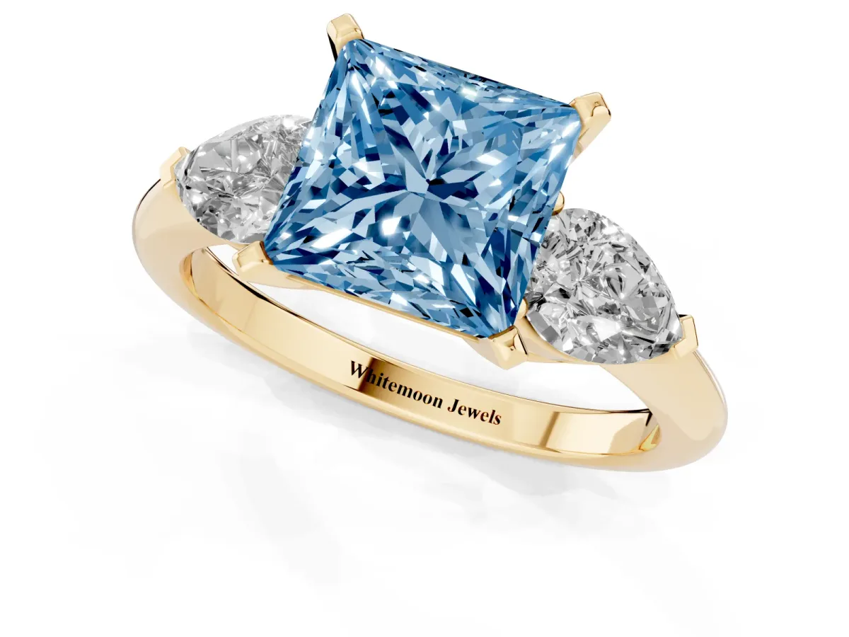 Fancy Blue Three-Stone Princess Cut Diamond Ring with Pear Side Stones and Four-Prong Setting Yellow gold
