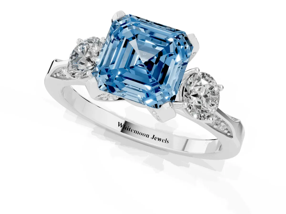 Fancy Blue Asscher Cut Brilliant Three-Stone Diamond Ring with Pavé Band and Four-Prong Setting White gold
