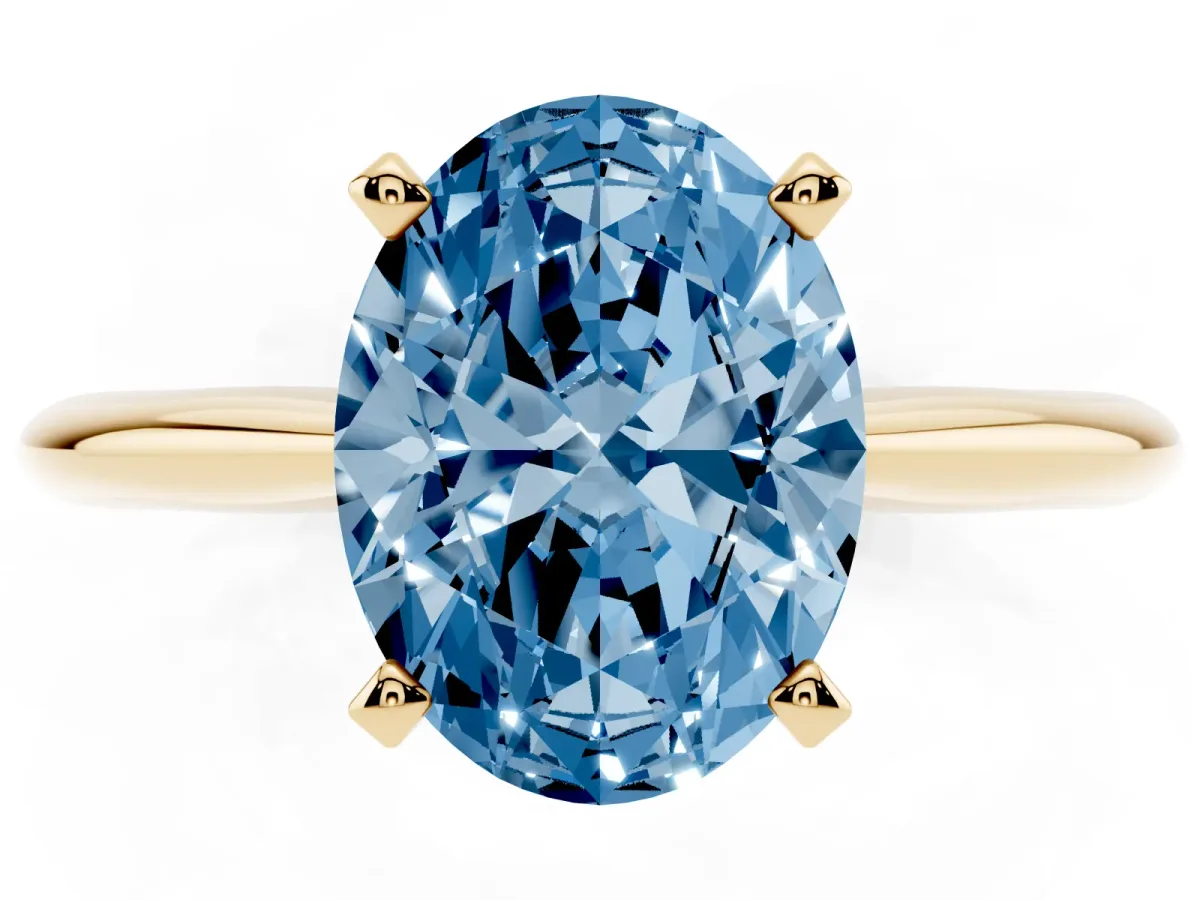 Fancy Blue Oval Cut Cut Solitaire Ring with Four-Prong Setting on a Classic Band Yellow gold