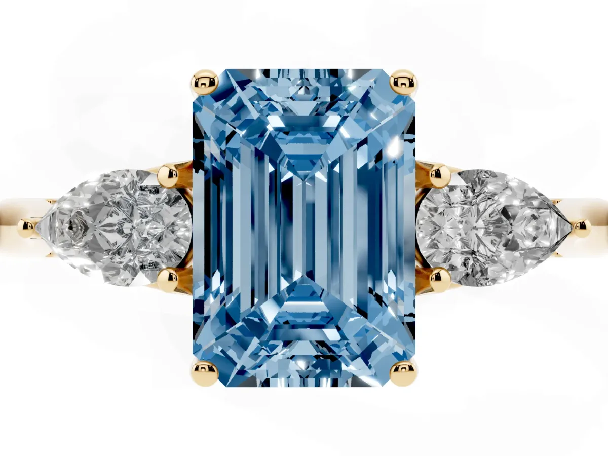 Fancy Blue Three-Stone Emerald Cut Brilliant Diamond Solitaire Ring with Tapered Band and Four-Prong Setting Yellow gold