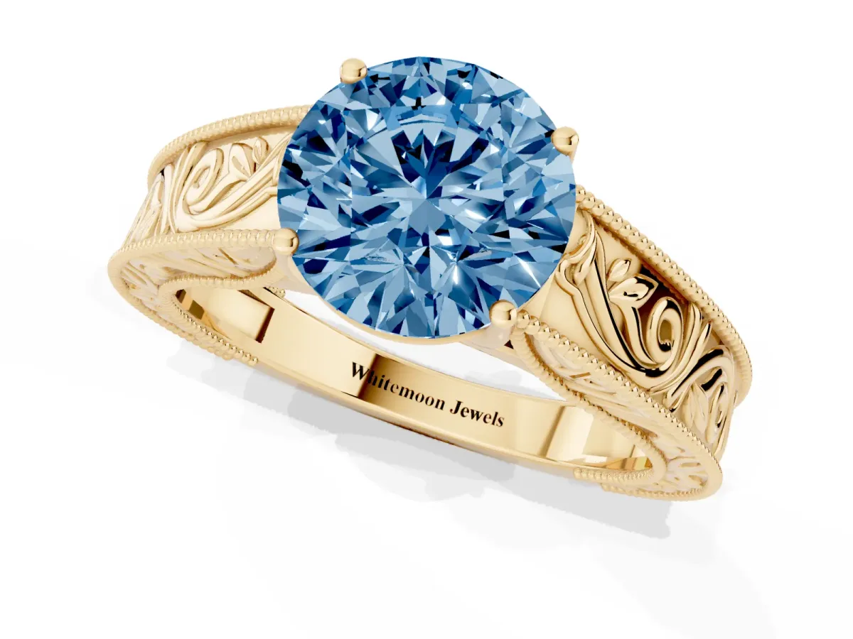 Fancy Blue Round Cut Diamond Solitaire Ring with Engraved Band and Four-Prong Setting Yellow gold